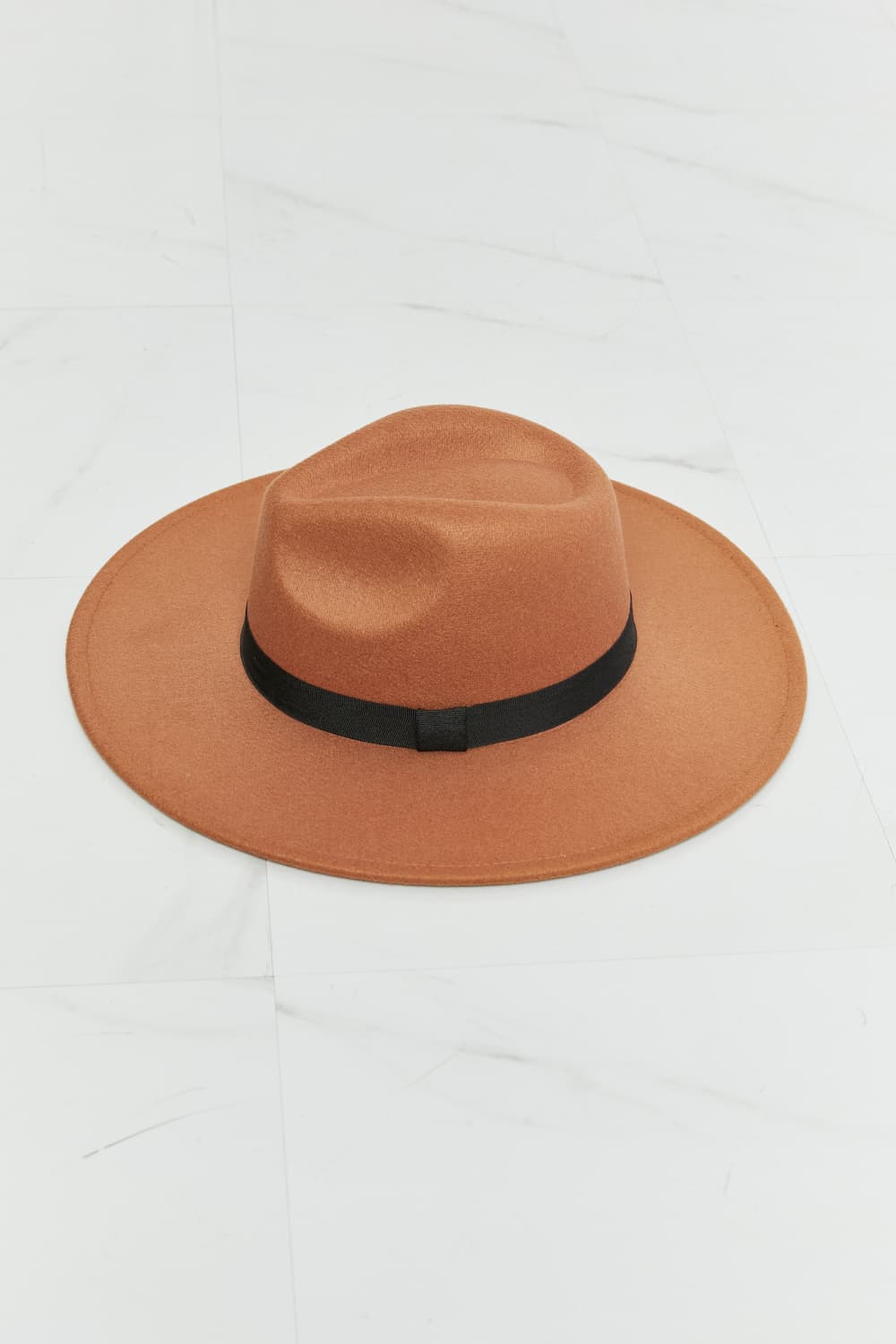 Fame Enjoy The Simple Things tan fedora hat with black ribbon band on marble surface