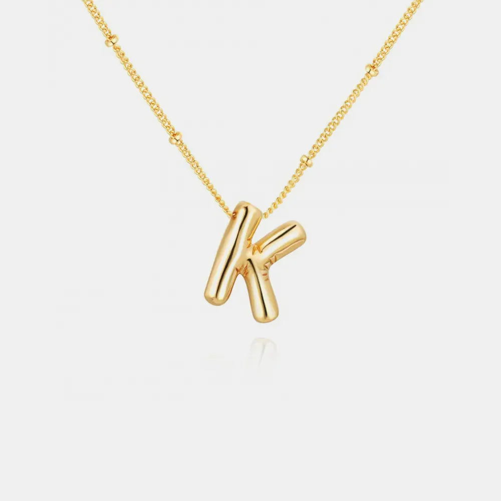 Gold-plated bubble initial necklace with letter K pendant on a delicate chain